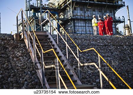 Picture - Workers talking at chemical plant. Fotosearch
