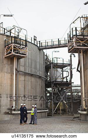 Stock Photography - Workers talking at chemical plant. Fotosearch