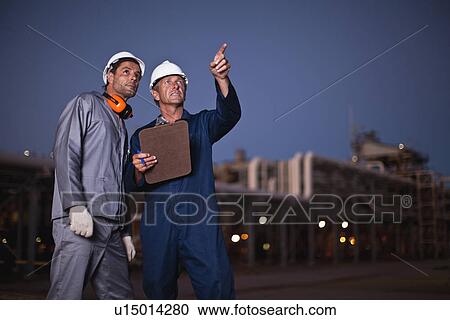 Workers talking at oil refinery View Large Photo Image Stock Image - Workers talking at oil refinery. Fotosearch