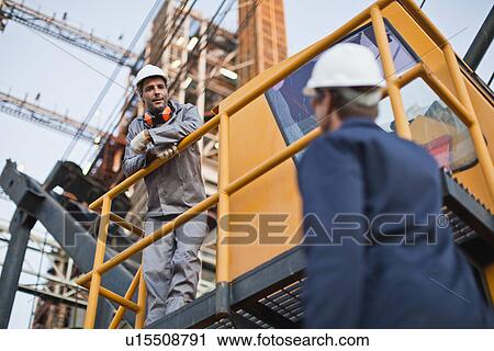 Workers talking at oil refinery View Large Photo Image Stock Image - Workers talking at oil refinery. Fotosearch