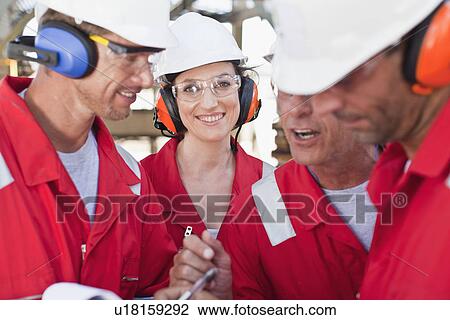 Workers talking at oil refinery View Large Photo Image Stock Image - Workers talking at oil refinery. Fotosearch