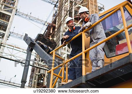 Workers talking at oil refinery View Large Photo Image Stock Image - Workers talking at oil refinery. Fotosearch