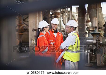 Stock Photograph - Workers talking at oil refinery. Fotosearch