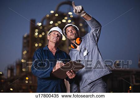 Workers talking at oil refinery View Large Photo Image Stock Photography - Workers talking at oil refinery. Fotosearch
