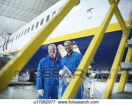 Workers talking in airplane hangar View Large Photo Image Stock Photo - Workers talking in airplane hangar. Fotosearch