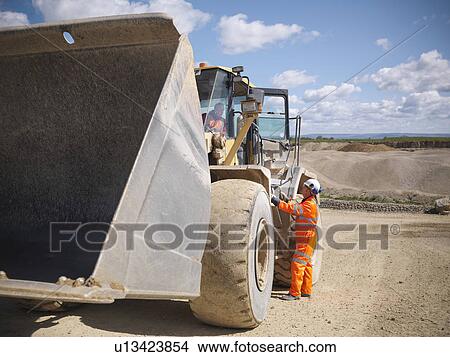 Workers talking on digger in quarry View Large Photo Image Picture - Workers talking on digger in quarry. Fotosearch