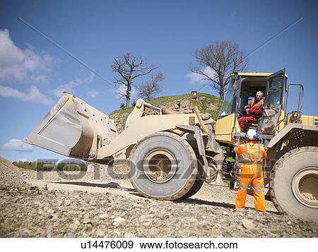 Workers talking on digger in quarry View Large Photo Image Stock Photo - Workers talking on digger in quarry. Fotosearch
