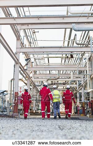 Stock Photo - Workers walking at chemical plant. Fotosearch