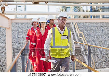 Stock Photo - Workers walking at chemical plant. Fotosearch