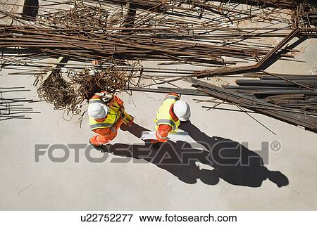 Stock Photo - Workers walking at construction site. Fotosearch