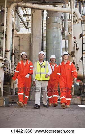 Workers walking at oil refinery View Large Photo Image Stock Photograph - Workers walking at oil refinery. Fotosearch