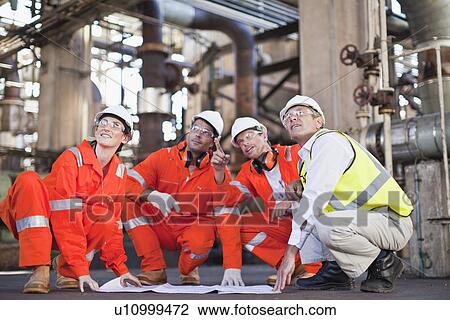 Workers with blueprints at oil refinery View Large Photo Image Stock Image - Workers with blueprints at oil refinery. Fotosearch