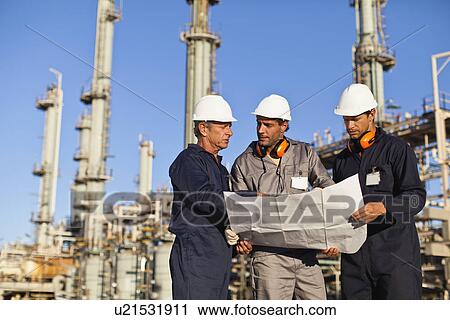 Workers with blueprints at oil refinery View Large Photo Image Stock Image - Workers with blueprints at oil refinery. Fotosearch