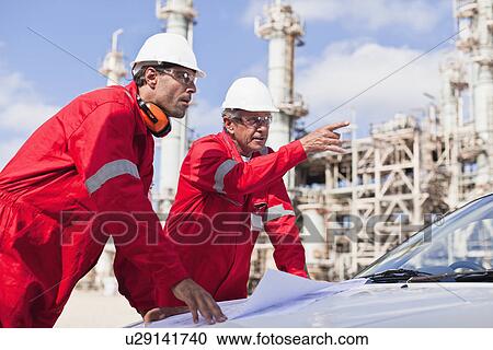 Workers with blueprints at oil refinery View Large Photo Image Stock Image - Workers with blueprints at oil refinery. Fotosearch