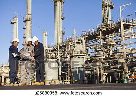 Stock Photo - Workers with blueprints at oil refinery. Fotosearch