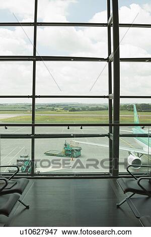 Stock Photo - Airplane viewed through an airport lounge window, Cork Airport, Cork, County Cork, Republic of Ireland. Fotosearch