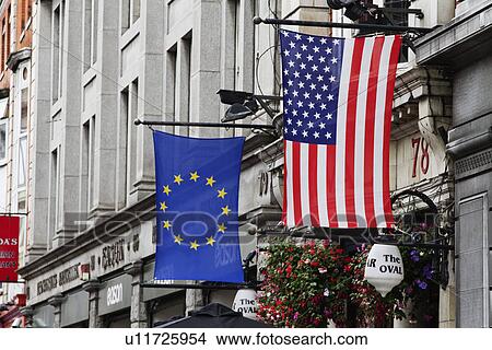 Picture - American flag and European Union flag hanging in front of a building, Republic of Ireland. Fotosearch
