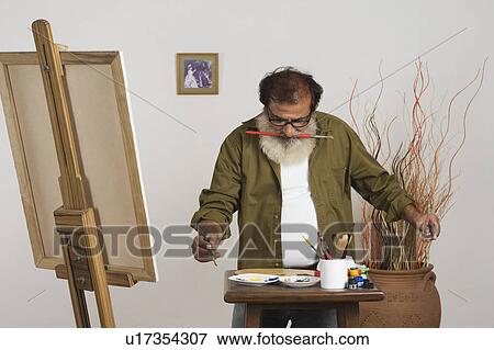 Artist choosing color for painting View Large Photo Image Stock Photo - Artist choosing color for painting. Fotosearch