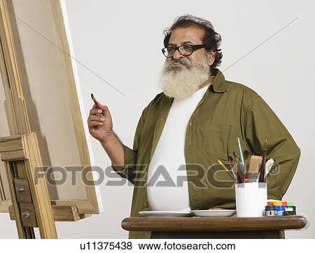 Artist looking at painting View Large Photo Image Stock Photo - Artist looking at painting. Fotosearch