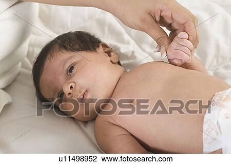 Baby lying on the bed View Large Photo Image Stock Image - Baby lying on the bed. Fotosearch