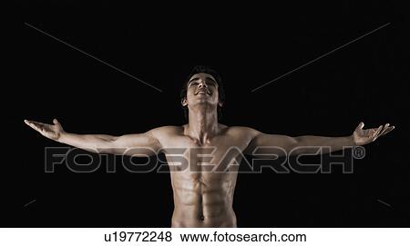 Bare chested man standing with arms outstretched View Large Photo Image Stock Photo - Bare chested man standing with arms outstretched. Fotosearch