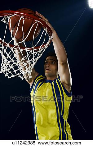 Stock Photography - Basketball player dunking a ball. Fotosearch