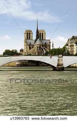 Stock Image - Bridge with a cathedral in the background, Notre Dame de Paris, Seine River, Paris, France. Fotosearch