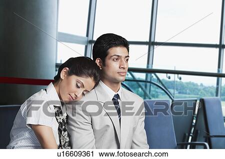 Stock Image - Business couple at an airport lounge. Fotosearch