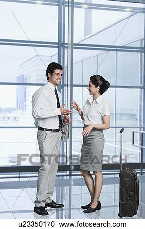 Stock Image - Business couple at an airport lounge. Fotosearch