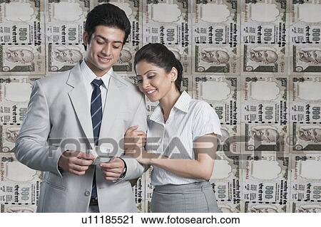 Business couple in front of a background of Indian currency notes View Large Photo Image Stock Image - Business couple in front of a background of Indian currency notes. Fotosearch