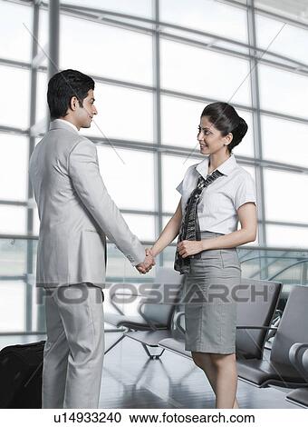 Business couple shaking hands at an airport lounge View Large Photo Image Stock Image - Business couple shaking hands at an airport lounge. Fotosearch