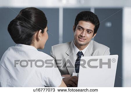 Stock Image - Business couple working on a laptop. Fotosearch