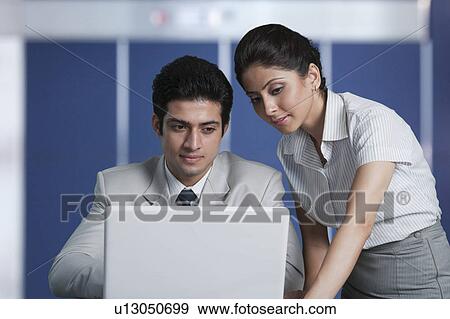 Business couple working on a laptop View Large Photo Image Stock Photo - Business couple working on a laptop. Fotosearch