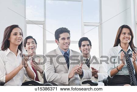 Stock Image - Business executives applauding at a meeting. Fotosearch
