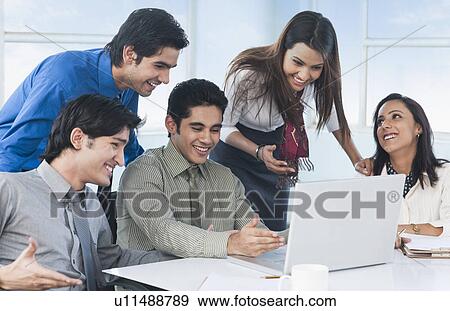 Stock Photo - Business executives looking at a laptop. Fotosearch