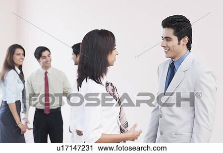 Stock Image - Business executives talking to each other. Fotosearch
