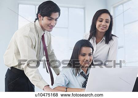 Stock Photo - Business executives working on a laptop. Fotosearch