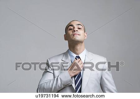 Businessman adjusting his tie View Large Photo Image Picture - Businessman adjusting his tie. Fotosearch