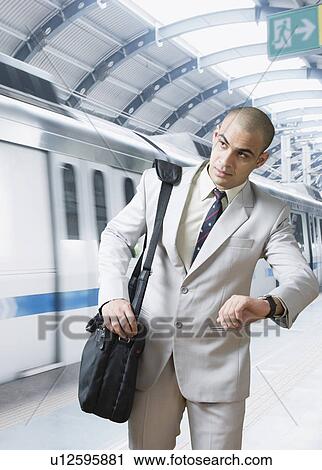 Stock Image - Businessman checking the time. Fotosearch
