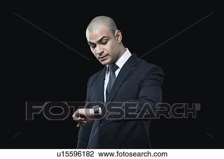 Businessman checking the time View Large Photo Image Stock Image - Businessman checking the time. Fotosearch