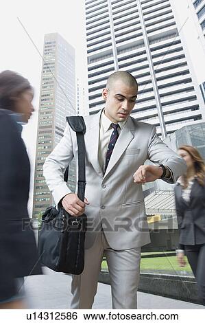 Businessman checking the time View Large Photo Image Stock Photograph - Businessman checking the time. Fotosearch