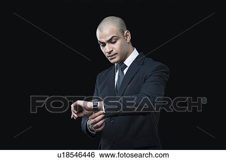 Businessman checking the time View Large Photo Image Stock Photograph - Businessman checking the time. Fotosearch