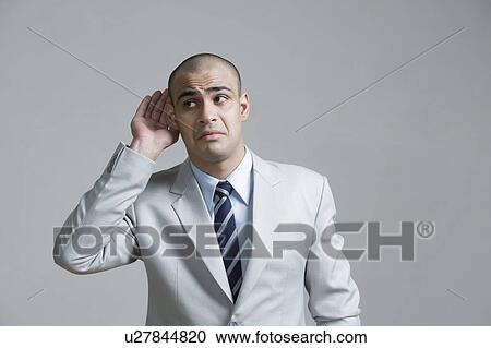 Businessman cupping hand to ear View Large Photo Image Stock Image - Businessman cupping hand to ear. Fotosearch