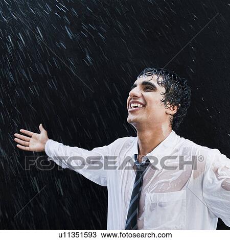 Stock Image - Businessman enjoying in the rain. Fotosearch