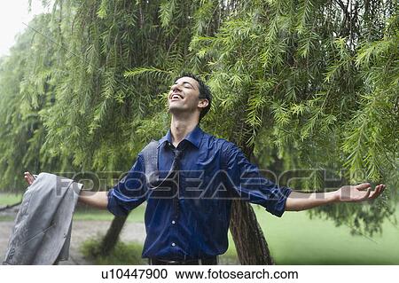 Businessman enjoying rain View Large Photo Image Stock Image - Businessman enjoying rain. Fotosearch