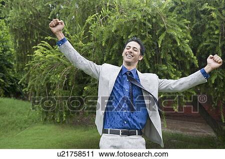 Stock Image - Businessman enjoying rain. Fotosearch