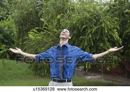 Stock Photo - Businessman enjoying rain. Fotosearch