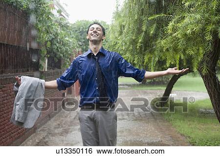 Businessman enjoying rain View Large Photo Image Stock Photograph - Businessman enjoying rain. Fotosearch
