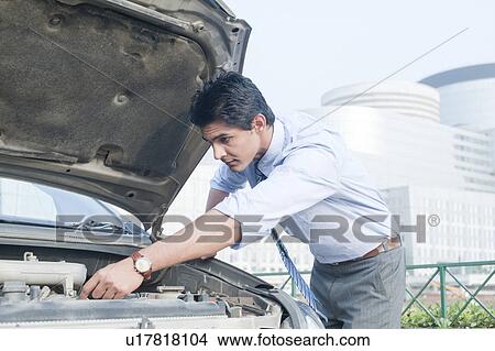 Businessman examining his broken down car, Gurgaon, Haryana, India View Large Photo Image Picture - Businessman examining his broken down car, Gurgaon, Haryana, India. Fotosearch