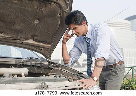 Businessman examining his broken down car, Gurgaon, Haryana, India View Large Photo Image Stock Photo - Businessman examining his broken down car, Gurgaon, Haryana, India. Fotosearch